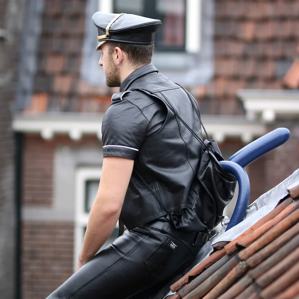 Guy in leather with crackstuffers dildos in his backpack
